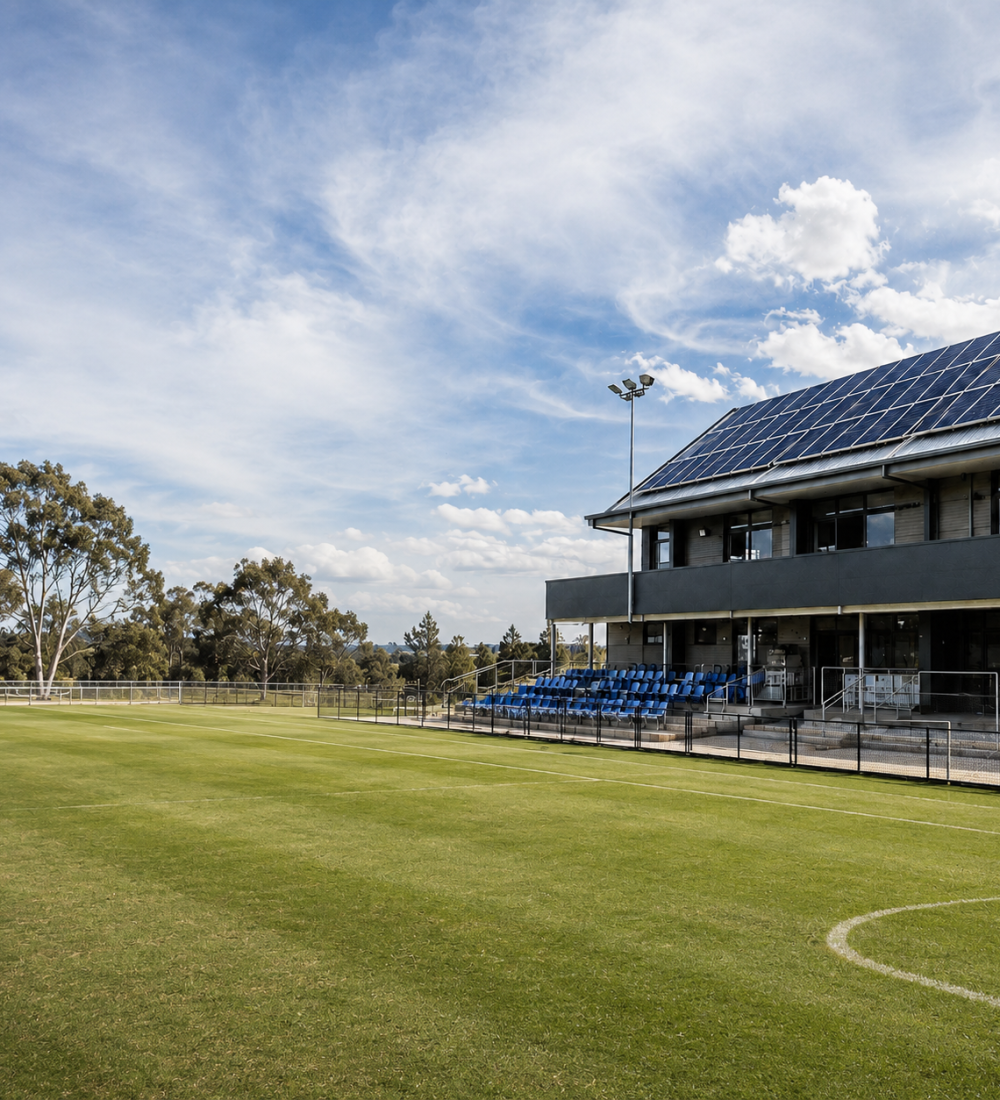 Sunny sports field with modern clubhouse
